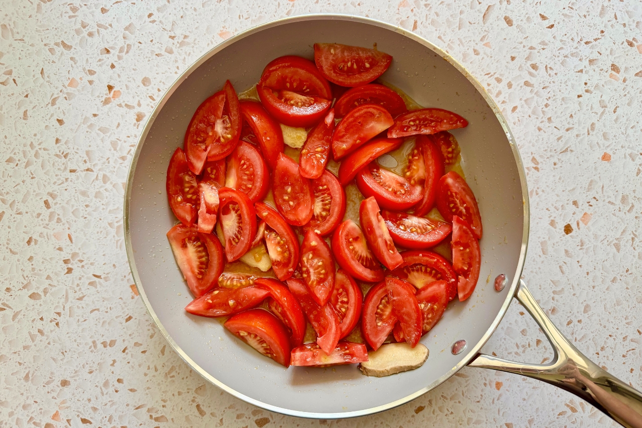 Tomatoes and ginger stir frying in pan
